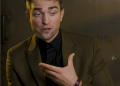 Image may contain Robert Pattinson Clothing Suit Overcoat Apparel Coat Human and Person