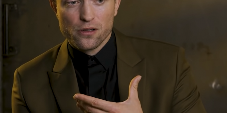 Image may contain Robert Pattinson Clothing Suit Overcoat Apparel Coat Human and Person