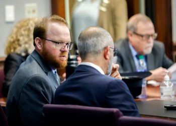 Travis McMichael, left, speaks with his attorney, Jason Sheffield, center, during the sentencing hearing for the murder of Ahmaud Arbery. Travis, his father, Gregory, right, and William "Roddie" Bryan were sentenced to life in prison Jan. 7 at the Glynn County Courthouse in Brunswick, Ga.