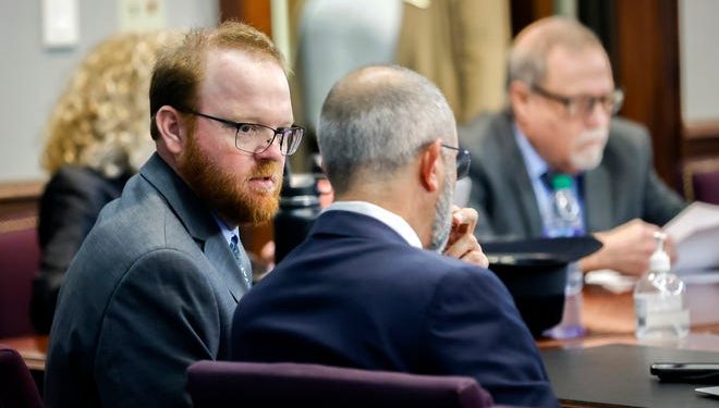 Travis McMichael, left, speaks with his attorney, Jason Sheffield, center, during the sentencing hearing for the murder of Ahmaud Arbery. Travis, his father, Gregory, right, and William "Roddie" Bryan were sentenced to life in prison Jan. 7 at the Glynn County Courthouse in Brunswick, Ga.