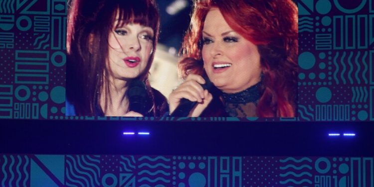 A screen projecting two women singing together