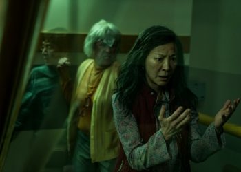 Michelle Yeoh looks at her hands as Jamie Lee Curtis raises a fist in "Everything Everywhere All At Once."