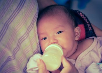 Baby drinking milk on mother's chest