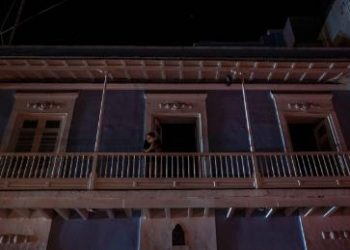 A man stands on a balcony in San Juan after a major power outage on April 6, 2022.