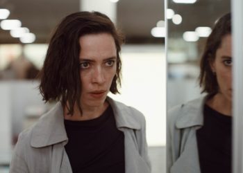 A woman and her reflection both look apprehensive.