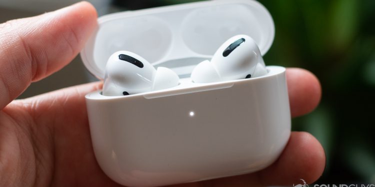 The Apple AirPods Pro earbuds charging case in a man's hand.
