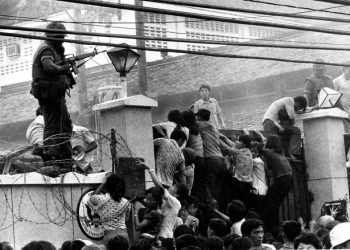 A group of people climbing a wall