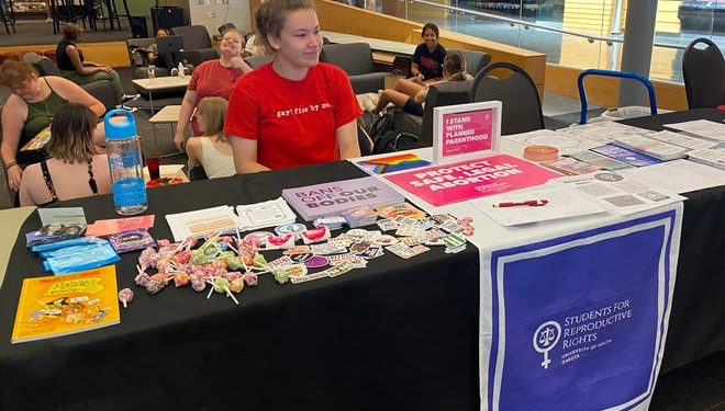 Anna Bottesini sits in the University of South Dakota student center ready to answer questions about abortion access and share resources with her fellow students.